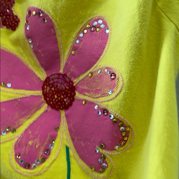It is a yellow shirt with a flower on it - Picture 3 of 4